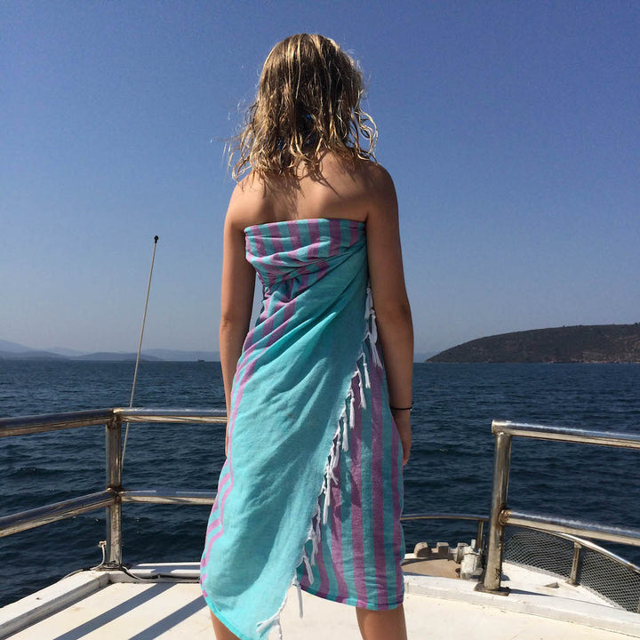 girl on ship's deck wearing clara hammam towel as a sarong