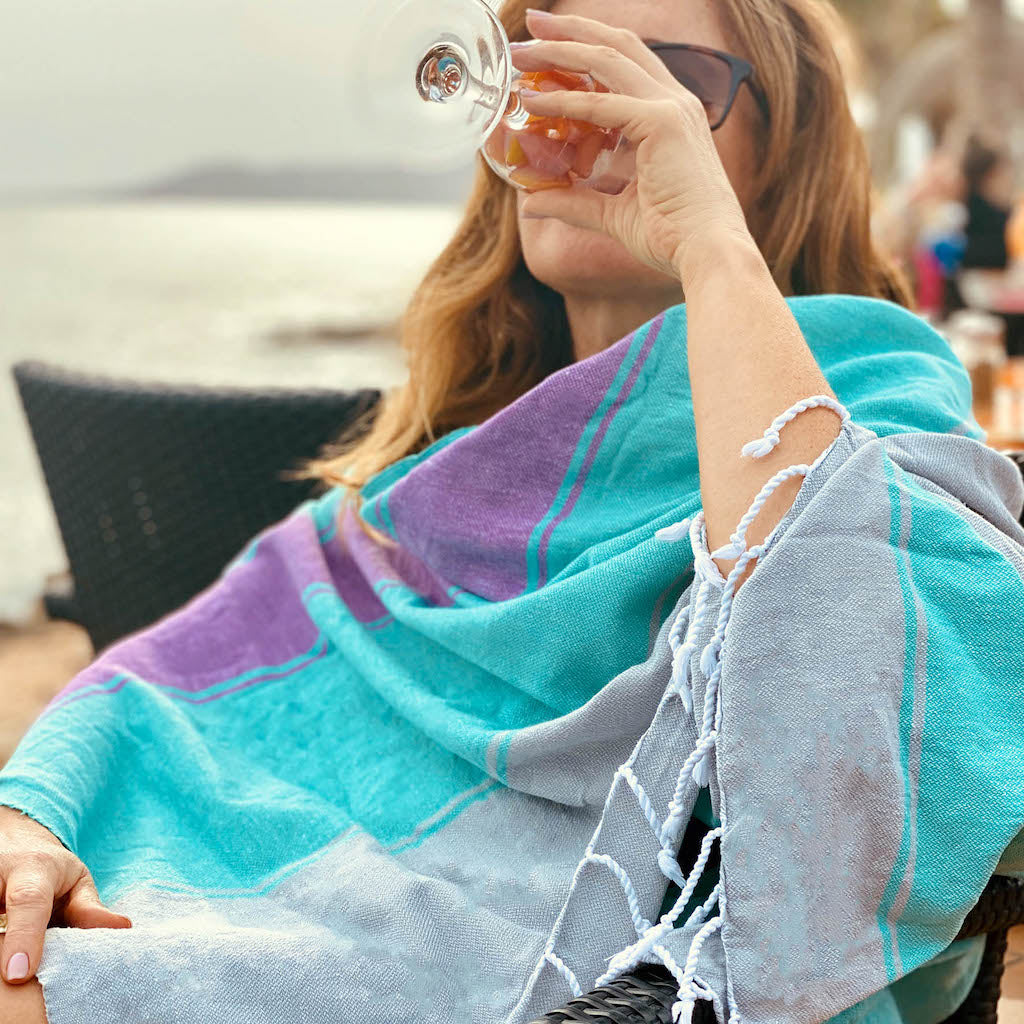 lady drinking wine wearing talia hammam towel as beach wrap
