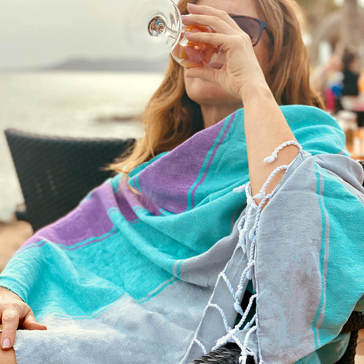 lady drinking wine wearing talia hammam towel as beach wrap