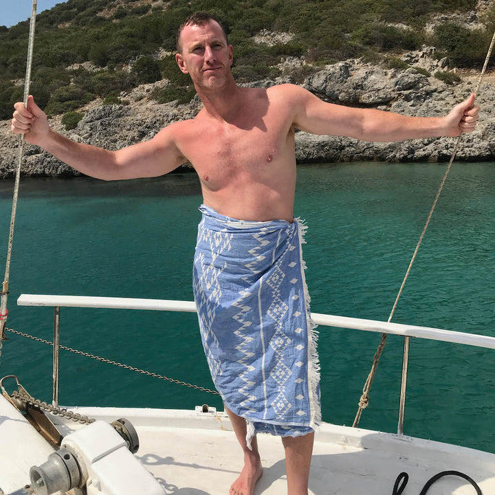 man on deck wearing blue hammam towel