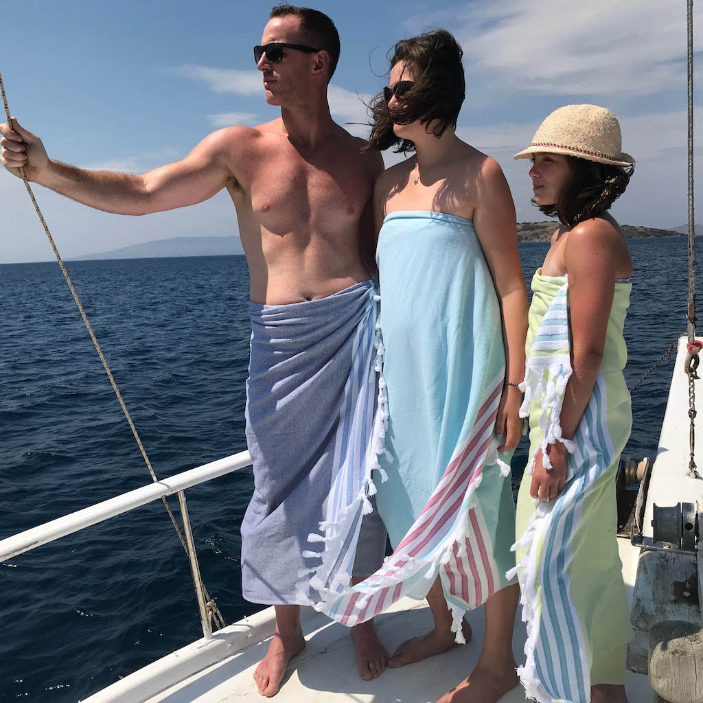 family wearing dina beach towels on boat