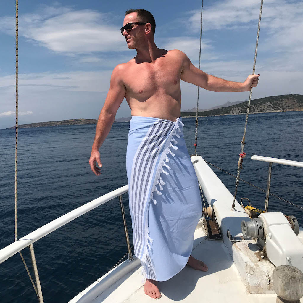 man wearing dina beach towel on boat