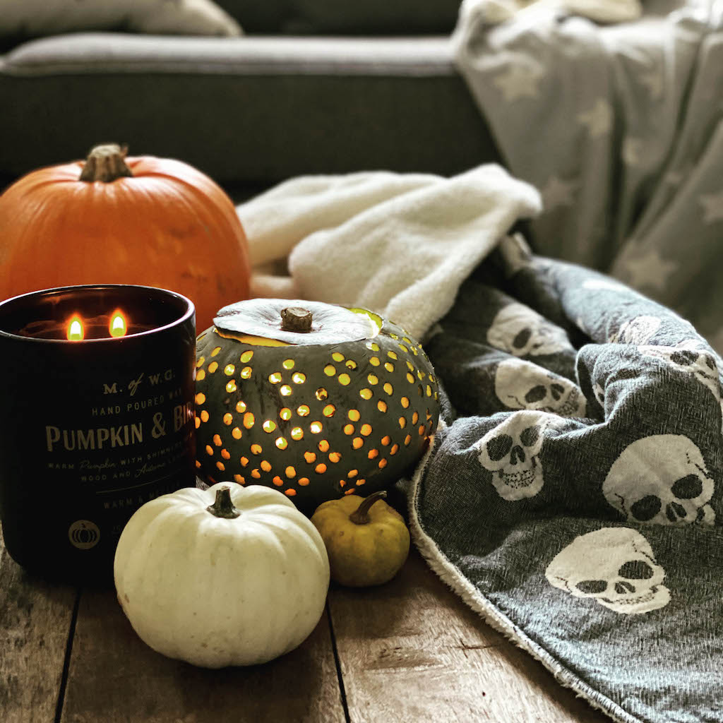 Skull fleece lined throw on table with halloween pumpkins
